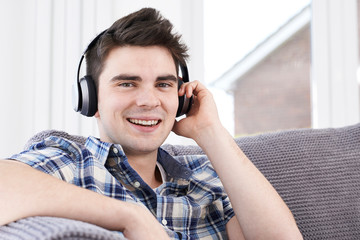 Young Man Listening To Music On Wireless Headphones