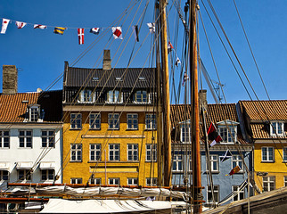 Antique houses with bright colorful facades and old ships moored at Nyhavn, Copenhagen