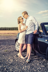 Pärchen steht verliebt am Cabrio - Liebespaar in Urlaubsstimmung