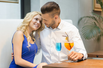 Beautiful couple at the bar drinking cocktails