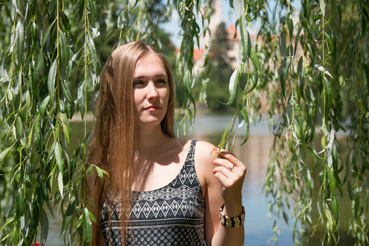 girl posing with willow vines in green garden