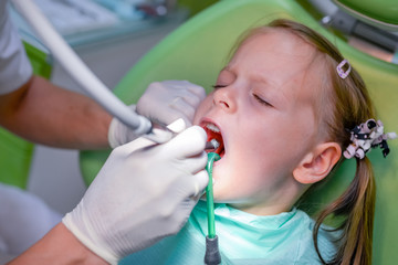 Little girl sitting in the dentists office - dental caries prevention