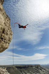 Tuinposter Jump off a cliff into a canyon with a rope. © vetal1983
