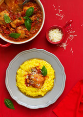 Baked rabbit in tomato sauce and served with risotto. Italian Cuisine.