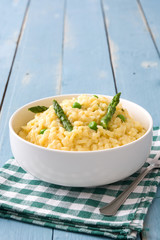 Risotto with asparagus, parsley and peas on a blue wooden table

