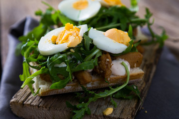 sandwich with meat, egg and arugula
