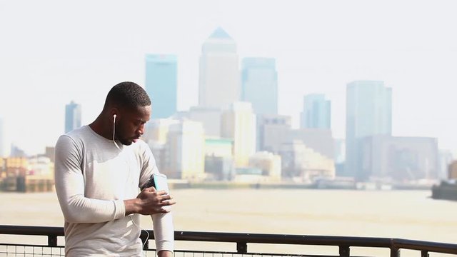Man adjusting portable device on arm