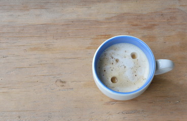 coffee with milk foam cup on wooden table