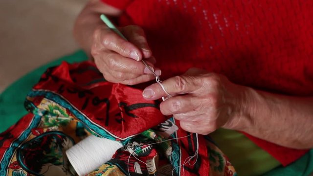 Old woman knits with spokes
