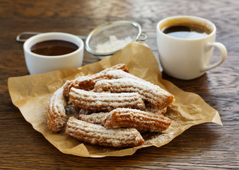 Churros with hot chocolate and powdered sugar.