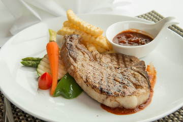  steak with pepper sauce on a plate together with vegetable