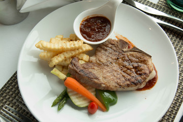  steak with pepper sauce on a plate together with vegetable