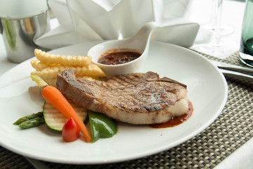  steak with pepper sauce on a plate together with vegetable