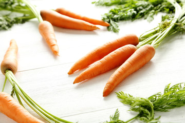 Fresh and sweet carrots on a white wooden table
