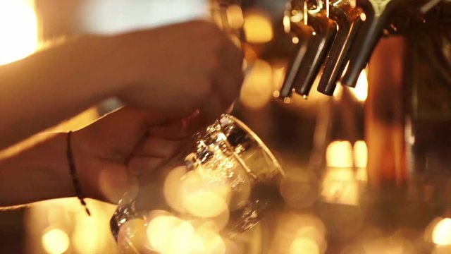 Male hands pours beer into a glass