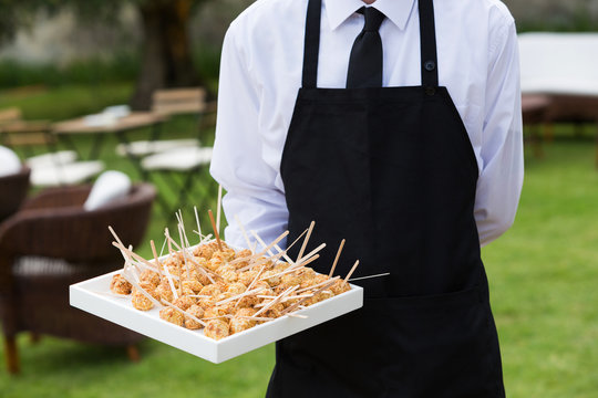 Waiter With Tray Of Food In Exterior