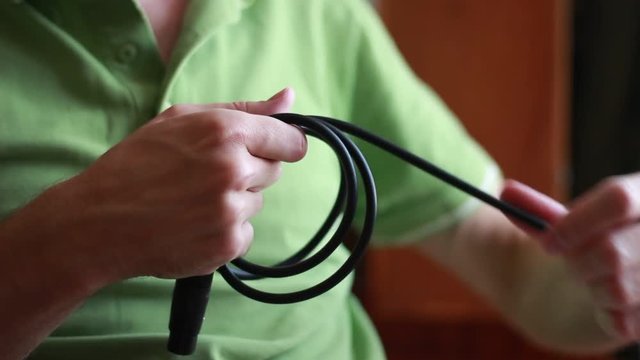 Man taking up michrophone cable