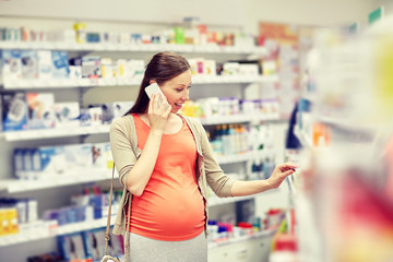 happy pregnant woman with smartphone at pharmacy