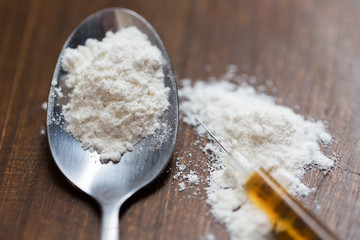 close up of spoon and syringe with drug dose