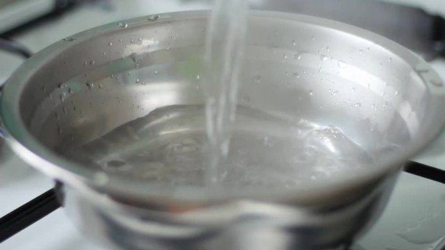 Pouring boiled water into a steel pan