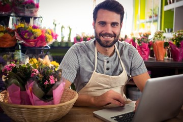 Male florist using laptop at his flower shop