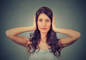 young attractive woman covering with hands her ears closed. Hear no evil concept