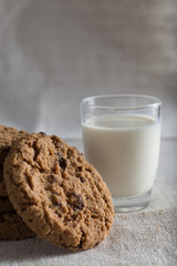 Cookies pile with chocolate chip on light textile background. Delicious morning snacks for breakfast, brunch and lunch. Appetizing, healthy, sweet, scrummy, and fast food.