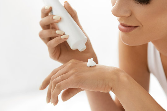 Hand Skin Care. Closeup Of Beautiful Woman Applying Cream