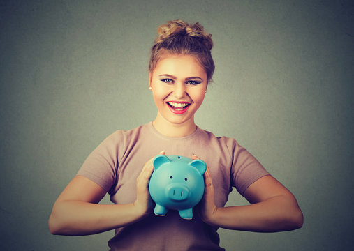 happy, smiling woman holding piggy bank. Financial savings, banking concept.