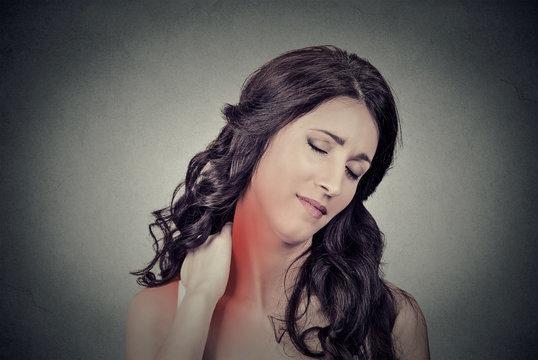 tired woman massaging her painful neck