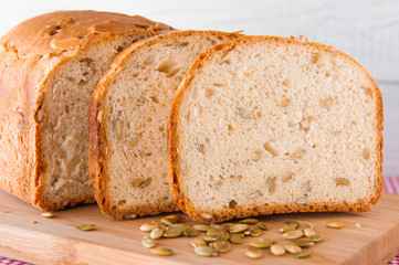 Loaf of white bread with green pumpkin seeds