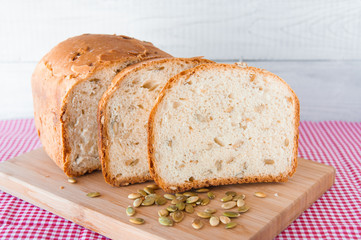 Loaf of white bread with green pumpkin seeds