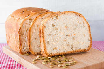 Loaf of white bread with green pumpkin seeds
