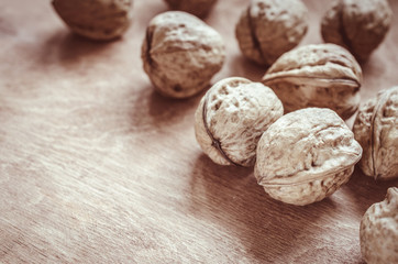 Whole walnuts on rustic old wooden table.