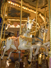 Fototapeta na wymiar An old fashioned carousel at night. Detail of two horses