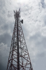 telecommunications tower with cloudy sky background.