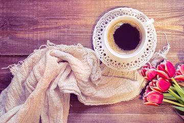 A cup of black coffee on soft napkin and lovely flowers on soft napkin . Romantic background with retro filter effect. top view.