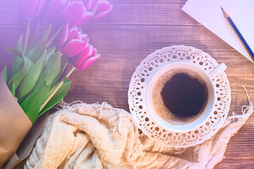 A cup of black coffee on soft napkin and lovely flowers on soft napkin . Romantic background with retro filter effect. top view.