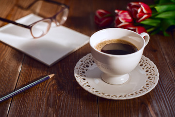 Coffee cup with note book and glases. Retro style pictures