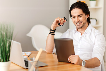 Pleasant positive man sitting at the table