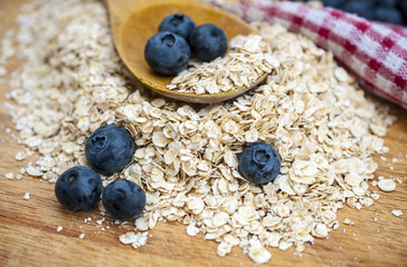 Oat flakes on the wooden table with milk and blueberry
