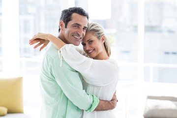 Fototapeta premium Portrait of mid adult couple hugging at home