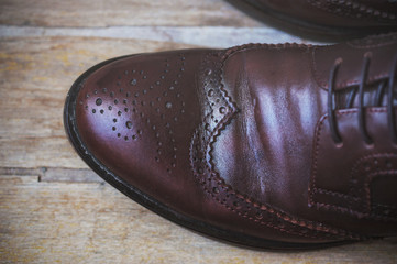 Image of male brown shoes over the wooden table