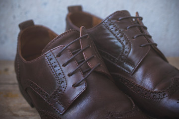 Image of male brown shoes over the wooden table