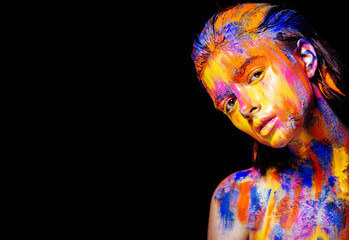 Art makeup. Face, neck and hair girls smeared with bright colors of yellow, blue and pink colors....