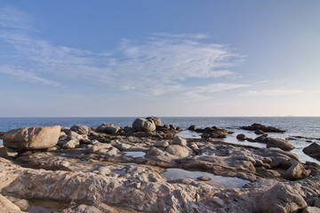 Tranquilo Rincón de rocas junto al mar con nubes y horizonte azul