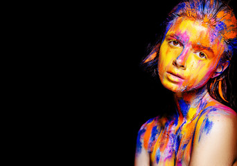 Art makeup. Face, neck and hair girls smeared with bright colors of yellow, blue and pink colors. Holi Festival