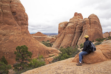 Fototapeta na wymiar Hiker resting on a trail at Arches National Park Moab Utah.