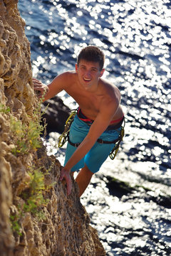 Climber Man climbs on rocky wall