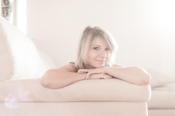 Obraz premium Cute young girl relaxing on couch at home. Hi key Softfocus Imag